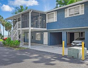 Fort Myers apartment for rent - A blue two-story house with a white car parked in the driveway.