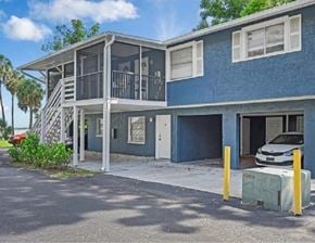 Fort Myers apartment for rent - A blue two-story house with a white car parked in the driveway.