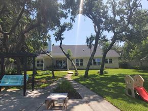 Gulf Breeze house for rent - a house with a playground and trees in front of it