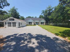 Gulf Breeze house for rent - a house with a gravel driveway and a lawn