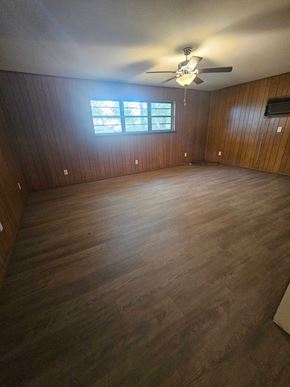 Pensacola house for rent - A room with wooden floors and a ceiling fan.