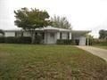 Pensacola house for rent - a white house with a yard and a tree in front of it