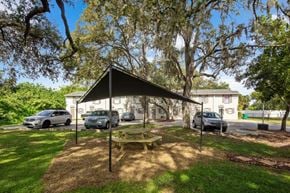 Bradenton apartment for rent - A picnic table is set up under a canopy in a grassy area.