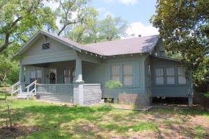 Leesville house for rent - a green house with a porch and a lawn