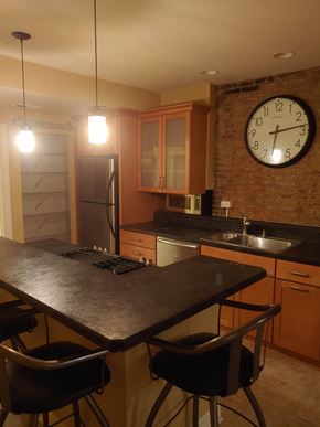 Pittsburgh apartment for rent - A kitchen with a black table and a brick wall clock.
