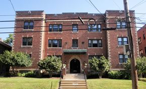 Pittsburgh apartment for rent - A large red brick building with a green lawn in front.
