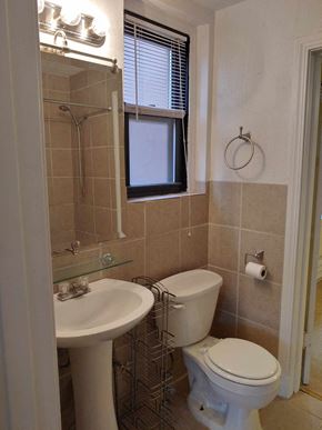 Pittsburgh apartment for rent - A white toilet sits next to a white sink in a bathroom.