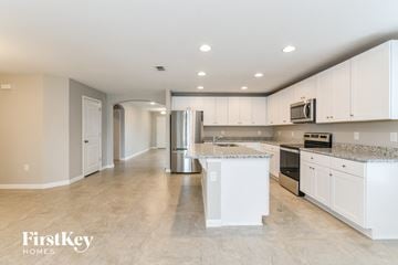 Davenport house for rent - A kitchen with white cabinets and a granite countertop.