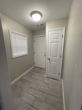 Jonesboro apartment for rent - A hallway with a white door and a window with blinds.