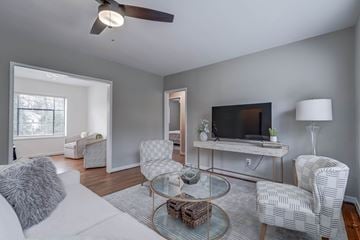 Richmond apartment for rent - A living room with a white couch, a glass coffee table, and a television on a stand.