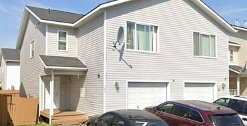 Anchorage apartment for rent - A house with a garage and a car parked in front.