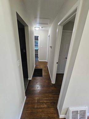 St. Louis house for rent - A long hallway with a white wall and a black door.