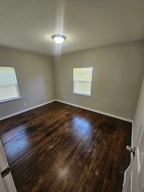 St. Louis house for rent - A room with wooden flooring and a window with blinds.