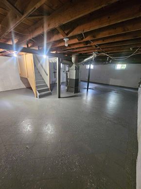 St. Louis house for rent - A spacious basement with a staircase and a window.