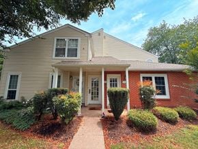 Holland house for rent - A house with a red brick wall and a white door.