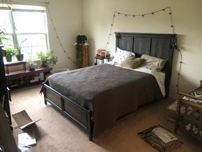 Holland house for rent - A bedroom with a bed, a window, and a plant on the windowsill.