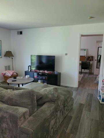 Holland house for rent - A living room with a grey couch and a black television.