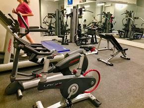 Kansas City apartment for rent - a woman walking through a gym filled with exercise bikes