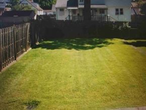Trevose apartment for rent - A white house with a green lawn and a wooden fence.
