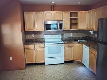 Trevose apartment for rent - A kitchen with wooden cabinets and a white oven.