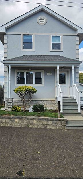 Trevose apartment for rent - A small house with a grey front and a tree in front of it.