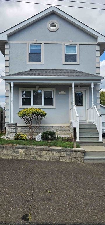 Trevose apartment for rent - A small house with a grey front and a tree in front of it.
