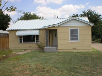 Levelland house for rent - a small yellow house with a tin roof