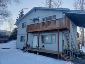 Eagle River apartment for rent - A house with a deck and stairs leading to the second floor.
