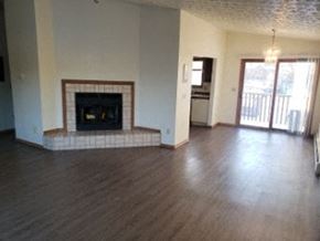 Eagle River apartment for rent - A living room with a fireplace and sliding glass doors.