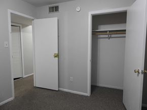 Bay City apartment for rent - A white door with a gold handle is open to a room with a grey carpet.