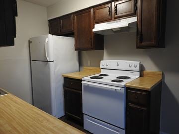 Bay City apartment for rent - A white refrigerator and a white stove with a wooden countertop in a kitchen.