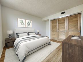 Los Angeles apartment for rent - A bedroom with a large bed, a nightstand with a lamp, and a wooden dresser with a book on top.