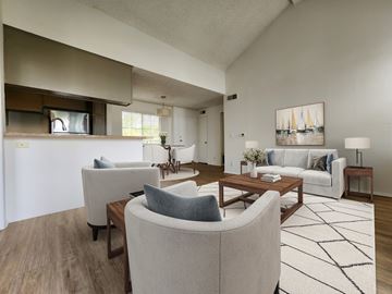 Los Angeles apartment for rent - A living room with a white couch, a grey armchair, a coffee table, and a painting on the wall.
