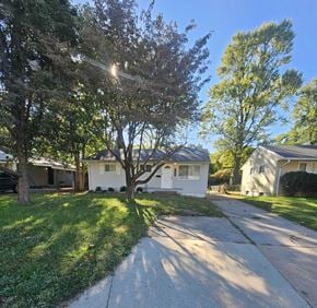 St. Louis house for rent - A tree in a front yard with a house in the background.