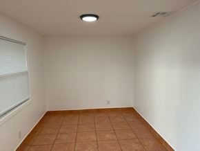Lake Worth apartment for rent - A room with a brown tile floor and a window with blinds.