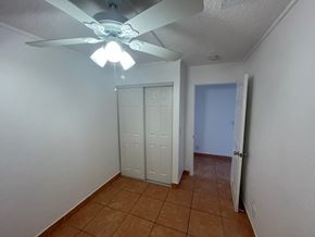 Lake Worth apartment for rent - A room with a ceiling fan and a brown tile floor.