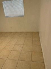 Fort Myers apartment for rent - A room with a tiled floor and a window with blinds.