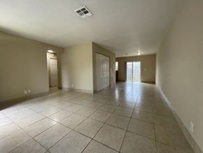 Lake Worth apartment for rent - A spacious room with tiled flooring and two doors.