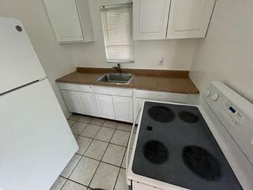Haverhill apartment for rent - A white kitchen with a black stove top.