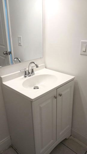 West Palm Beach apartment for rent - A white bathroom sink with a white cabinet and a mirror above it.