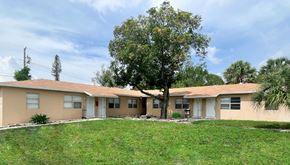 West Palm Beach apartment for rent - A building with a tree in front of it.