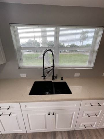 Lake Worth apartment for rent - A kitchen with white cabinets and a black sink.
