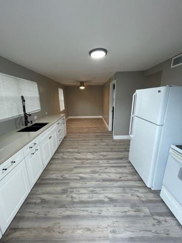 Lake Worth apartment for rent - A white refrigerator is in a kitchen with wood flooring.