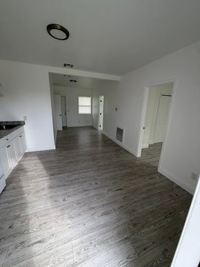 Lake Worth apartment for rent - A spacious room with wooden flooring and white walls.