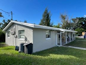 North Fort Myers apartment for rent - a small white house with a yard and grass