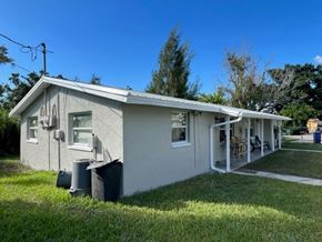 North Fort Myers apartment for rent - A small house with a white exterior and a green lawn in front.