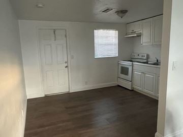 North Fort Myers apartment for rent - A kitchen with white cabinets and a wooden floor.