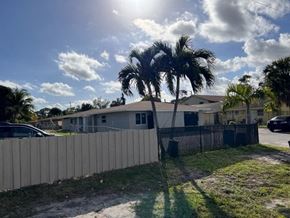 West Palm Beach apartment for rent - A sunny day with palm trees and a house in the background.
