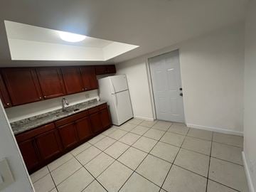 West Palm Beach apartment for rent - A kitchen with white appliances and brown cabinets.