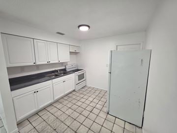 Fort Myers apartment for rent - A kitchen with white cabinets and a white refrigerator.